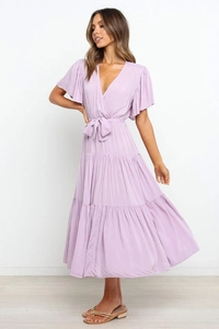 Detalle de vestido bohemio lila con cuello en V, mangas con volantes y lazo en la cintura