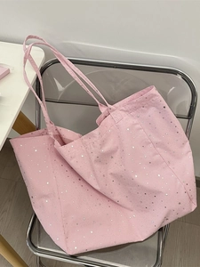 Pink canvas tote bag with silver star prints and striped lining on an acrylic chair