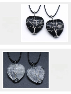 Detail view of 30mm obsidian and clear quartz heart necklaces with wire-wrapped tree of life