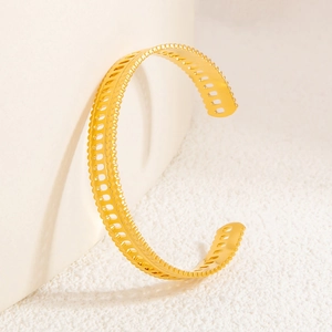Detailed view of gold 18k open cuff bracelet with hollow trapezoid Roman design