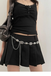 Close-up of vintage silver waist chain with concentric spiral textures and ball pendant