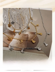 Detailed shot of gold and silver charms featuring moon, flower, and paw pendant designs