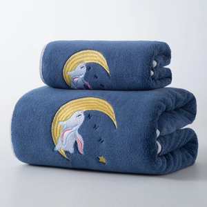 Detail of soft blue coral fleece bath towel with moon rabbit embroidery and plush texture