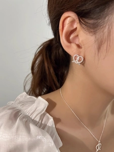 Polished silver twisted knot jewelry set with earrings and necklace on model