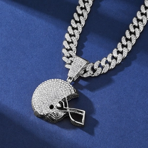 Macro view of silver American football helmet pendant with crystals on Cuban link chain