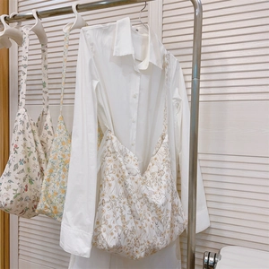 Detailed texture of cotton tote bags with floral and rabbit prints on a hanger