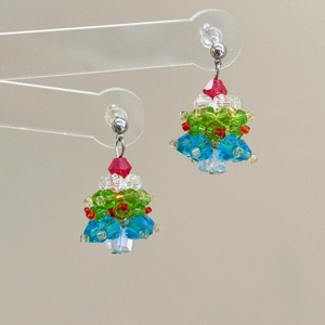 Detailed view of handmade beaded Christmas tree earrings with red bow and crystal beads