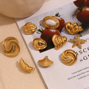 Selection of 18K gold plated shell and heart brooches with pearls on a fashion magazine