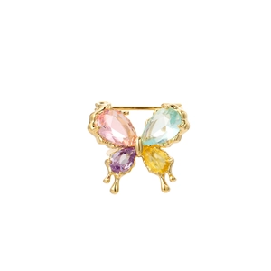 Detailed macro view of colorful pear-cut crystal butterfly brooch with golden liquid edges