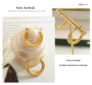 Detailed view of chunky 18K gold plated hoop earrings with high-polished metallic finish