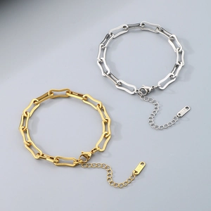 Close-up of gold and silver Cuban chain bracelets with lobster clasp and K18 engraving