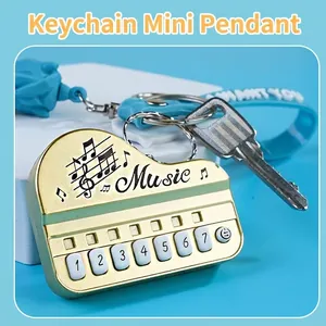 Mini gold electronic piano keychain with blue lanyard and numeric music buttons