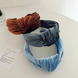 Detail showing textured velvet knotted headbands in brown, dark blue and light blue colors