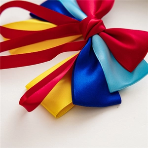 Macro detail of vibrant layered satin ribbon bow hair clip in red yellow and blue