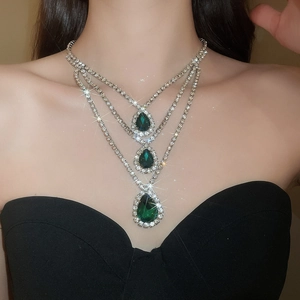 Dettaglio dell'elegante collana d'argento a tre strati con ciondoli a goccia verde brillante