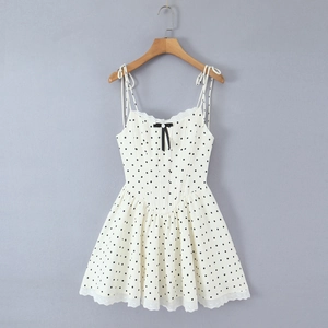Detailed view of the black bow and delicate lace trim on white polka dot dress