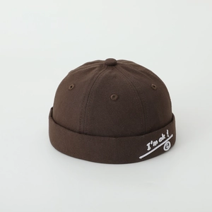 Detailed view of the dark brown cotton brimless cap featuring I'm ok smiley embroidery