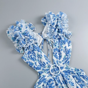 Detail of floral dress showing deep V-neck, ruffle sleeves, and belted pleated fabric