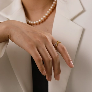 Detail von 18K Gold und Silber Kreuzringen mit Diamanten an einer Modellhand