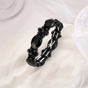Close-up of black oval crystal elastic bracelet with intricate floral stone settings