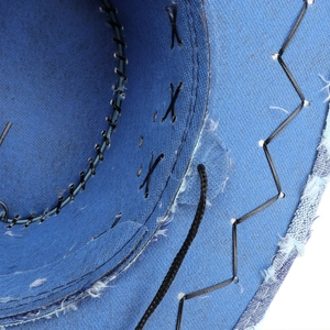 Detailed macro view of denim cowboy hat interior with reinforced stitching and frayed edges