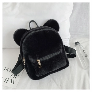 Detail of soft black plush backpack featuring cute bear ears and golden zippers
