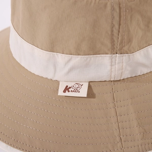 Macro detail of fine stitching and branded logo tag on a khaki sun hat for kids
