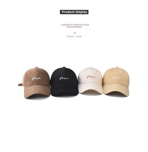 Detail showing various colors of cotton baseball caps with delicate 'me' embroidery
