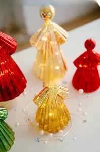 Close-up of golden glass angel ornaments with warm LED lights and vertical stripes