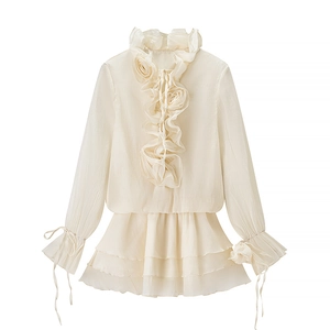 Detail of apricot ruffle blouse with 3D floral accents and flared lace-up sleeves