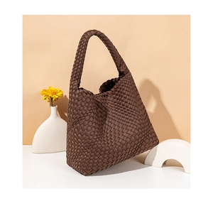 Detail shot of the brown woven texture and soft structure of the large shoulder bag