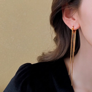 Élégantes boucles d'oreilles créoles dorées à longues franges sur un mannequin