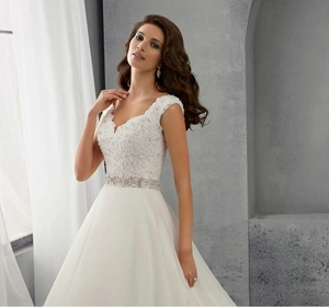 Détails de dentelle florale blanche et paillettes étincelantes sur une robe de mariée à col en V