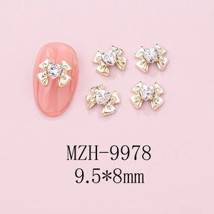 Macro view of golden bow nail art charms with heart crystals, sized 9.5x8mm