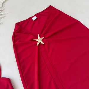 Détail d'une jupe en résille rouge avec boucle étoile de mer dorée et étiquette taille S