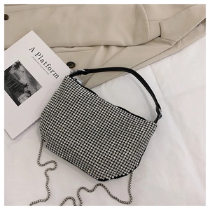 Close-up of silver rhinestone underarm bag with black leather strap and metal chain