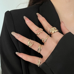 Close-up of woman wearing a set of six gold lava textured and open adjustable rings