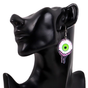 Detail view of cartoon eyeball earring with green pupil and drips on a black mannequin