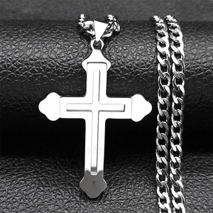 Détail macro du pendentif croix double couche en acier argenté sur cuir noir