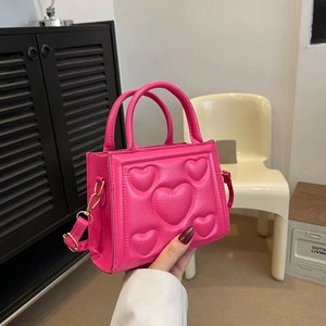 Petit sac bandoulière rose à motif cœurs matelassés avec chaîne dorée et poignée