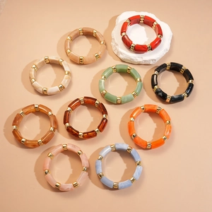Bamboo style resin bangles in various colors with gold metal spacers on stone base