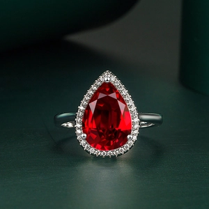 Elegant pear-shaped red gemstone ring with micro-pave diamonds on silver band