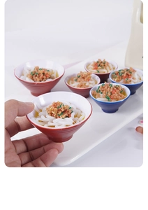 Dettaglio di ciotole di spaghetti in miniatura con condimenti realistici e vivaci
