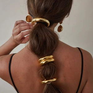 Minimalist gold stainless steel metal hair rings for ponytail styling on a female model