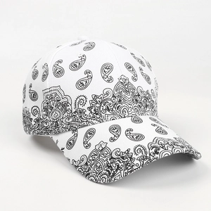 Close-up of white baseball cap featuring black paisley pattern and six-panel crown