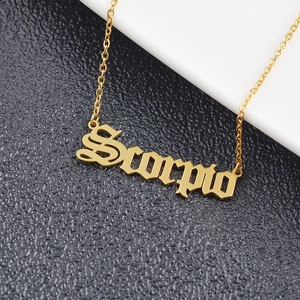 Macro detail of gold Scorpio zodiac necklace pendant in gothic font style