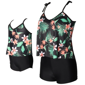 Detail of matching tropical floral tankini swimsuits with bow straps and boyleg shorts