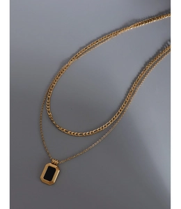 Detail of double-layered gold plated necklace with black rectangular geometric pendant