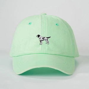 Close-up of mint green washed cotton baseball cap with black and white dog embroidery