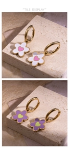 Détail de boucles d'oreilles fleur or avec breloques émail blanc-rose et violet-vert sur pierre